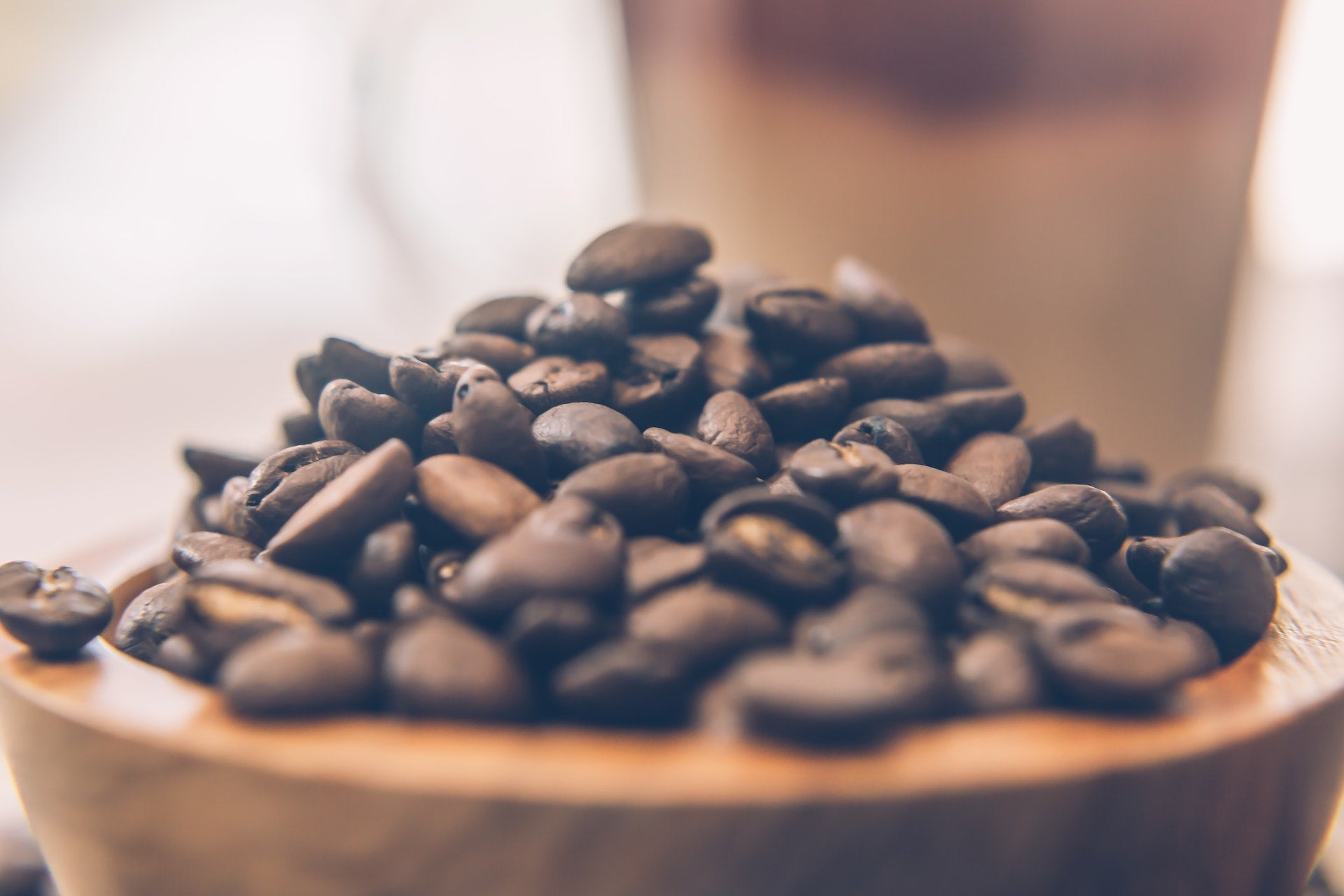 Small wooden bowl filled with freshly roasted coffee beans